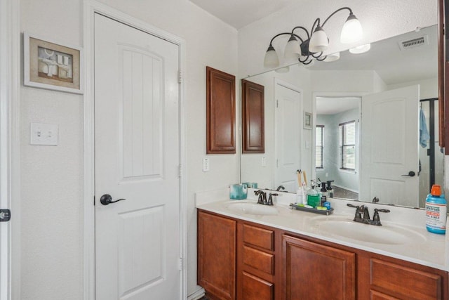 full bath featuring visible vents, a sink, and double vanity