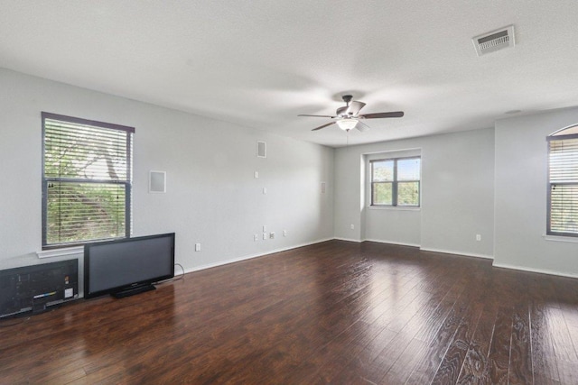spare room featuring baseboards, ceiling fan, wood-type flooring, and visible vents