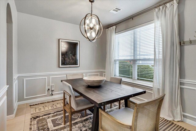 5684 Sabbia Dr, Round Rock, TX 78665 - dining room featuring a chandelier, light tile patterned floors, and wainscoting