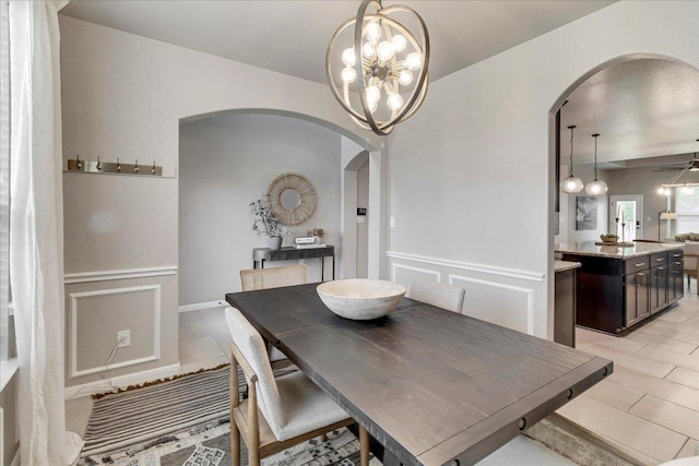 5684 Sabbia Dr, Round Rock, TX 78665 - dining room with arched walkways, light tile patterned floors, a chandelier, and ceiling fan
