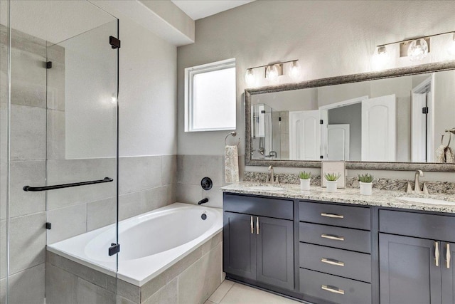 full bath featuring double vanity, a tile shower, a sink, and a garden tub