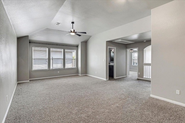 5684 Sabbia Dr, Round Rock, TX 78665 - carpeted spare room featuring a ceiling fan, plenty of natural light, vaulted ceiling, and a textured ceiling