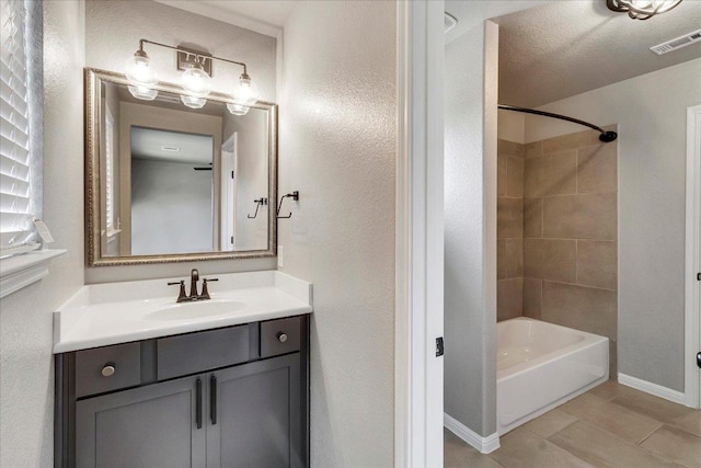 bathroom featuring visible vents, tile patterned flooring, vanity, baseboards, and  shower combination
