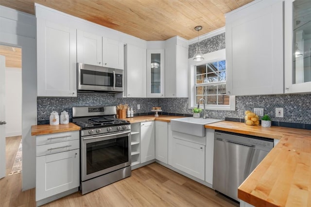 1802 Webberville Rd, Austin, TX 78721 - kitchen featuring light wood-type flooring, wood ceiling, a sink, wood counters, and stainless steel appliances