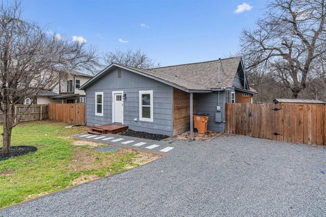 1802 Webberville Rd, Austin, TX 78721 - view of front facade featuring fence, a shingled roof, a front yard, a gate, and gravel driveway