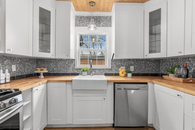 1802 Webberville Rd, Austin, TX 78721 - kitchen with stainless steel appliances, wooden counters, a sink, and tasteful backsplash