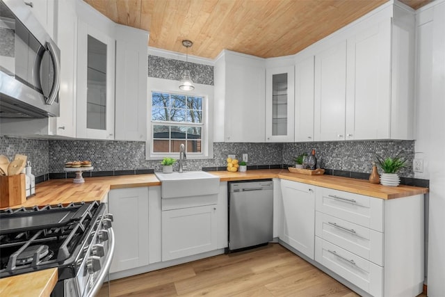 1802 Webberville Rd, Austin, TX 78721 - kitchen featuring stainless steel appliances, tasteful backsplash, wooden counters, and wood ceiling