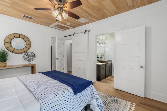 1802 Webberville Rd, Austin, TX 78721 - bedroom featuring visible vents, a barn door, wood ceiling, and light wood-type flooring
