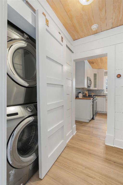 1802 Webberville Rd, Austin, TX 78721 - clothes washing area with laundry area, wood ceiling, stacked washer / dryer, and light wood-type flooring
