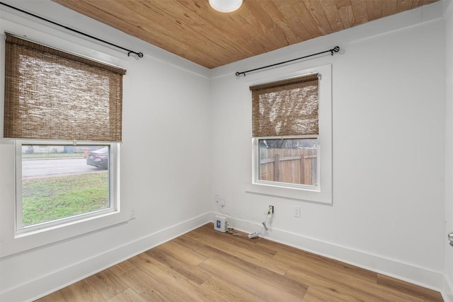 1802 Webberville Rd, Austin, TX 78721 - unfurnished room with baseboards, wooden ceiling, and light wood-type flooring