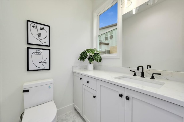 bathroom with baseboards, marble finish floor, toilet, and vanity