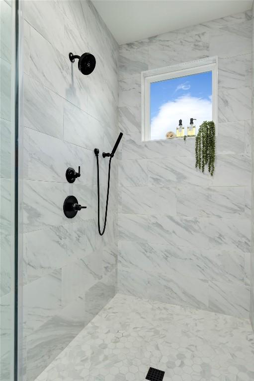 bathroom featuring a marble finish shower