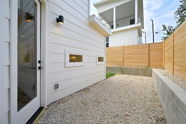 view of home's exterior with board and batten siding and fence