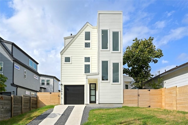 contemporary home featuring an attached garage, fence, a chimney, and driveway