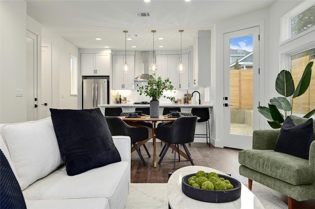 living area with recessed lighting, visible vents, and wood finished floors