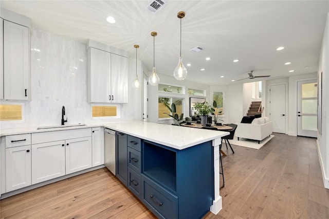 kitchen with recessed lighting, a sink, white cabinetry, and a peninsula