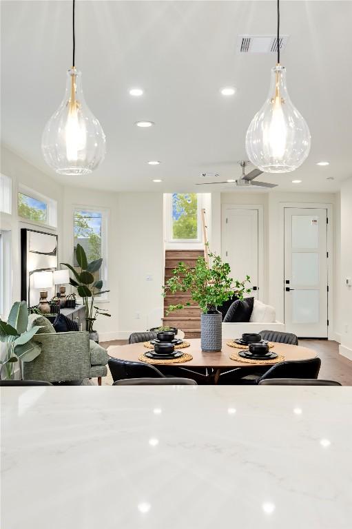kitchen with recessed lighting, decorative light fixtures, visible vents, and light stone counters