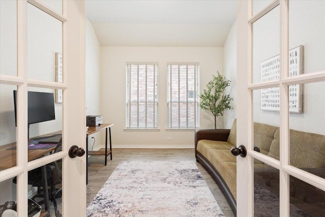 living area featuring baseboards, french doors, and wood finished floors