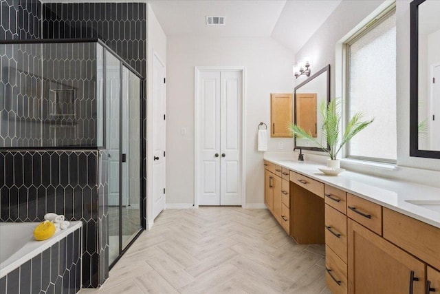full bath with visible vents, double vanity, baseboards, a stall shower, and tiled bath