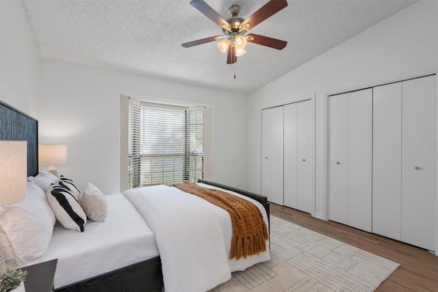 1601 Faro Dr Unit 1102, Austin, TX 78741 - bedroom featuring a ceiling fan, a textured ceiling, vaulted ceiling, light wood-style floors, and multiple closets