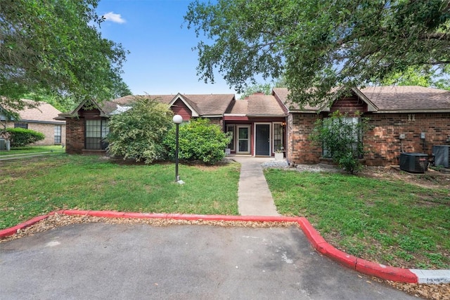 1601 Faro Dr Unit 1102, Austin, TX 78741 - view of front of home featuring central air condition unit, a front lawn, and brick siding