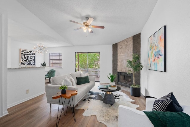 1601 Faro Dr Unit 1102, Austin, TX 78741 - living room with lofted ceiling, wood finished floors, baseboards, a large fireplace, and ceiling fan with notable chandelier