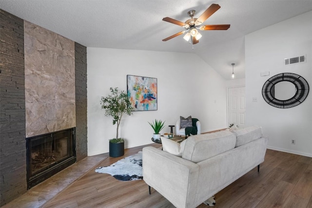 1601 Faro Dr Unit 1102, Austin, TX 78741 - living room featuring wood finished floors, a ceiling fan, a fireplace, lofted ceiling, and baseboards