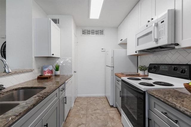 1601 Faro Dr Unit 1102, Austin, TX 78741 - kitchen featuring white appliances, a sink, backsplash, and dark stone counters