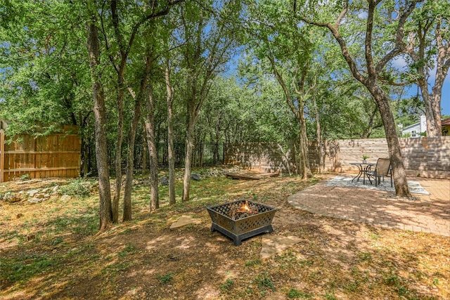 fenced backyard featuring an outdoor fire pit and a patio area