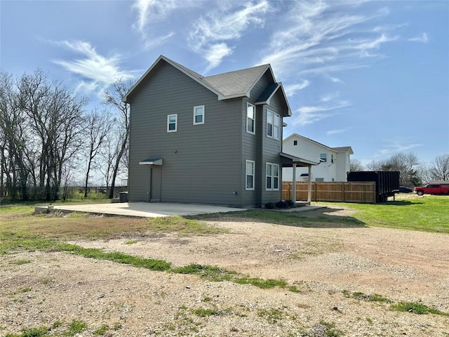 view of property exterior with a patio and fence