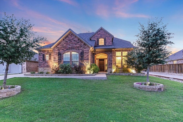 french country inspired facade featuring brick siding, stone siding, and roof with shingles