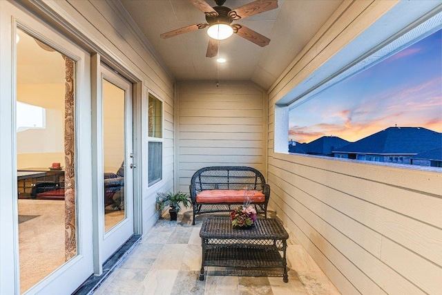 balcony at dusk featuring ceiling fan