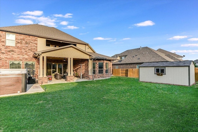 back of house with brick siding, an outbuilding, a storage unit, and a patio