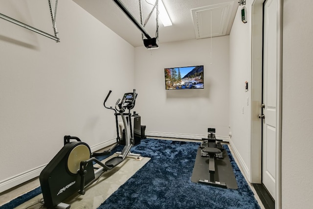 workout area with attic access, carpet flooring, and baseboards