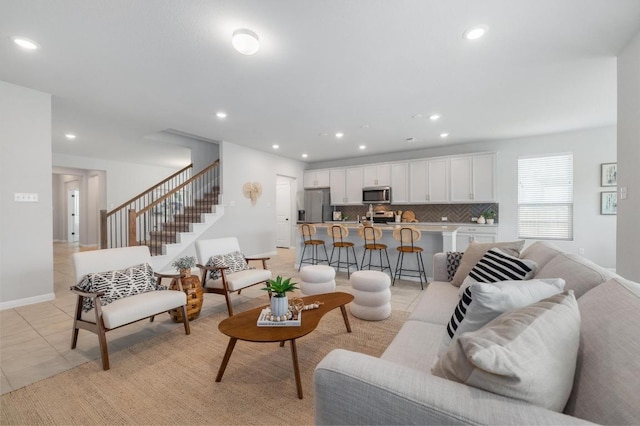 living room featuring stairs, recessed lighting, baseboards, and light tile patterned flooring