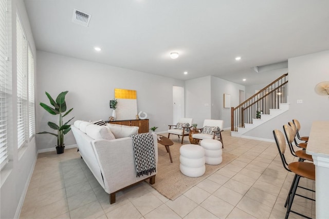living area with visible vents, stairway, light tile patterned floors, baseboards, and recessed lighting