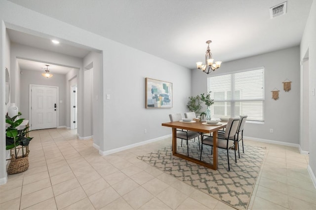 dining space featuring baseboards, a notable chandelier, visible vents, and light tile patterned floors