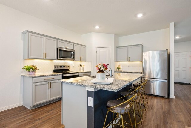 kitchen featuring appliances with stainless steel finishes, gray cabinets, and dark wood finished floors