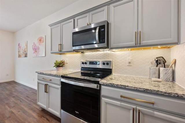 kitchen featuring appliances with stainless steel finishes, dark wood-style floors, gray cabinetry, and tasteful backsplash