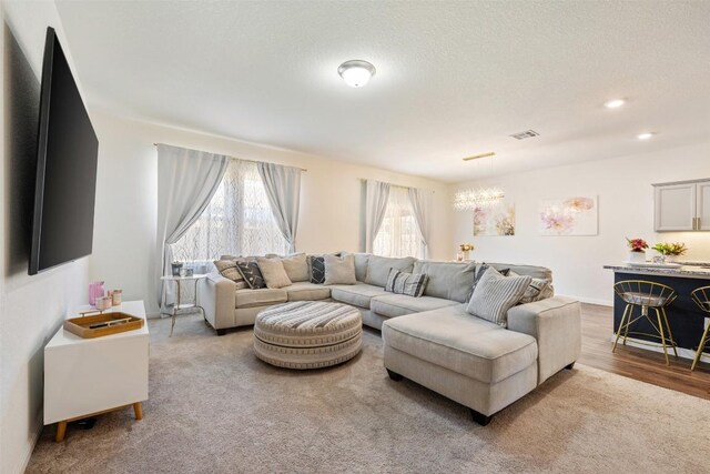 living area featuring a notable chandelier, wood finished floors, and visible vents