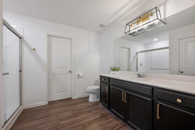 full bath with visible vents, wood finished floors, toilet, baseboards, and a stall shower