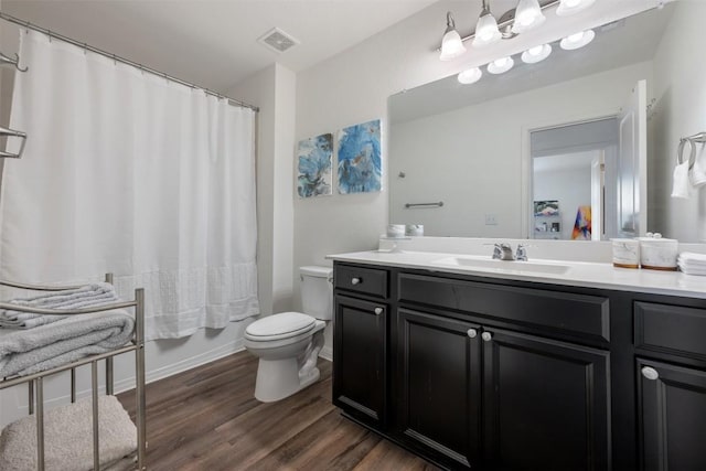 full bathroom featuring toilet, visible vents, wood finished floors, and vanity