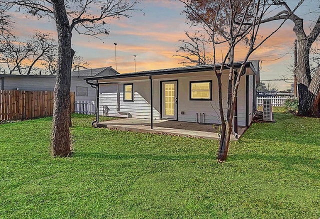 704 Sheffield Ave, Llano, TX 78654 - back of property at dusk with a lawn and fence