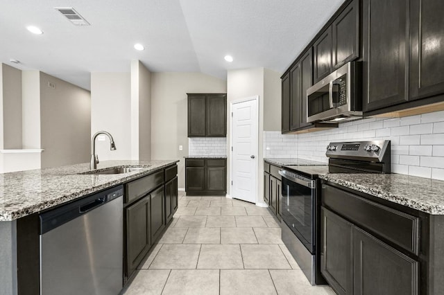 5407 Thunderbird St, Lago Vista, TX 78645 - kitchen featuring visible vents, appliances with stainless steel finishes, tasteful backsplash, light stone countertops, and a sink