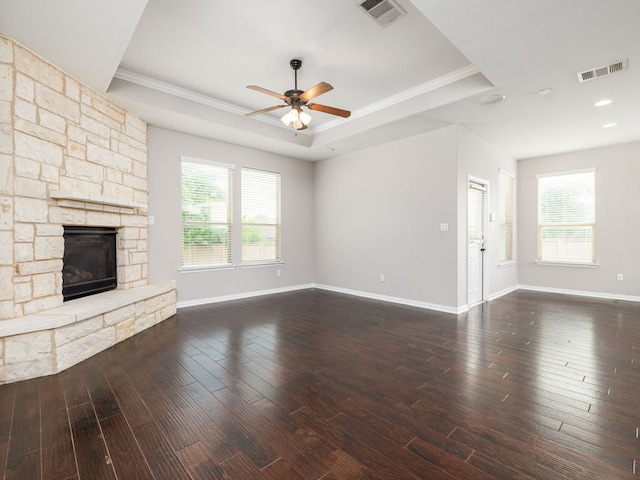 2040 Elaina Loop, Leander, TX 78641 - unfurnished living room with a raised ceiling, a ceiling fan, a stone fireplace, crown molding, and baseboards