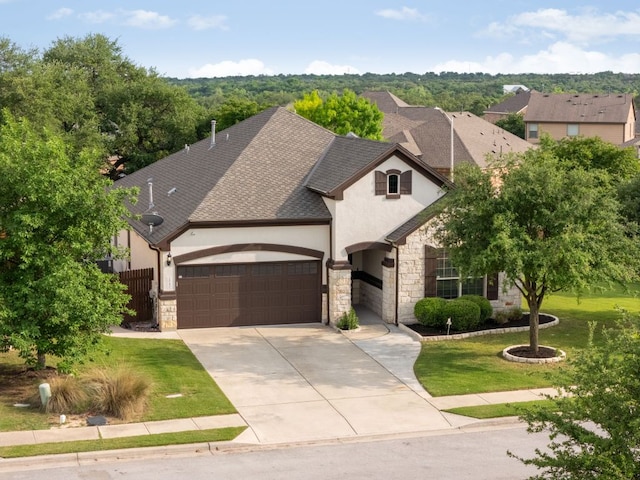 french country inspired facade with roof with shingles, stucco siding, a garage, and stone siding