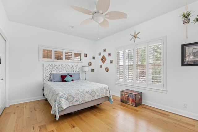 bedroom featuring a ceiling fan, baseboards, and light wood-style floors