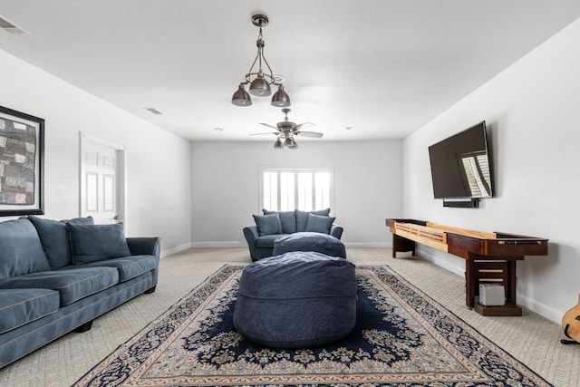 living area featuring a ceiling fan, baseboards, light colored carpet, and visible vents