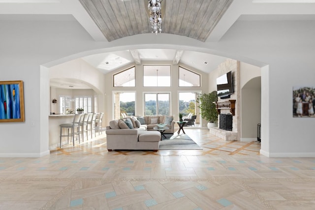 living area with arched walkways, baseboards, and a healthy amount of sunlight