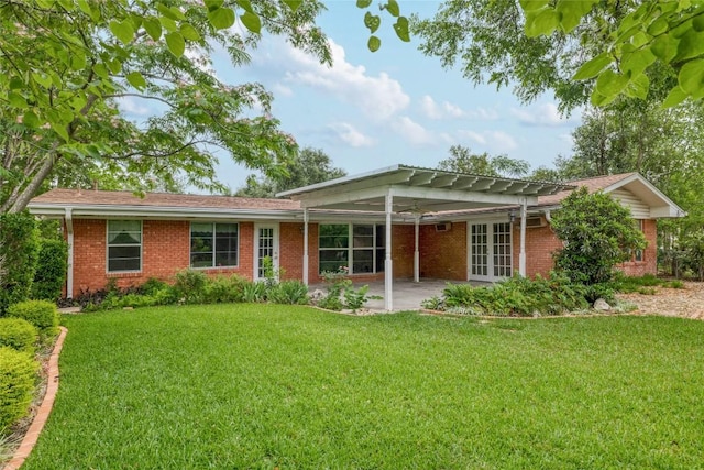 7300 Greenhaven Dr, Austin, TX 78757 - view of front of home with french doors, a front yard, and brick siding